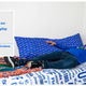 Image for article titled We Challenged Two Guys To Decorate A Dorm Room Using Only Fan Merch